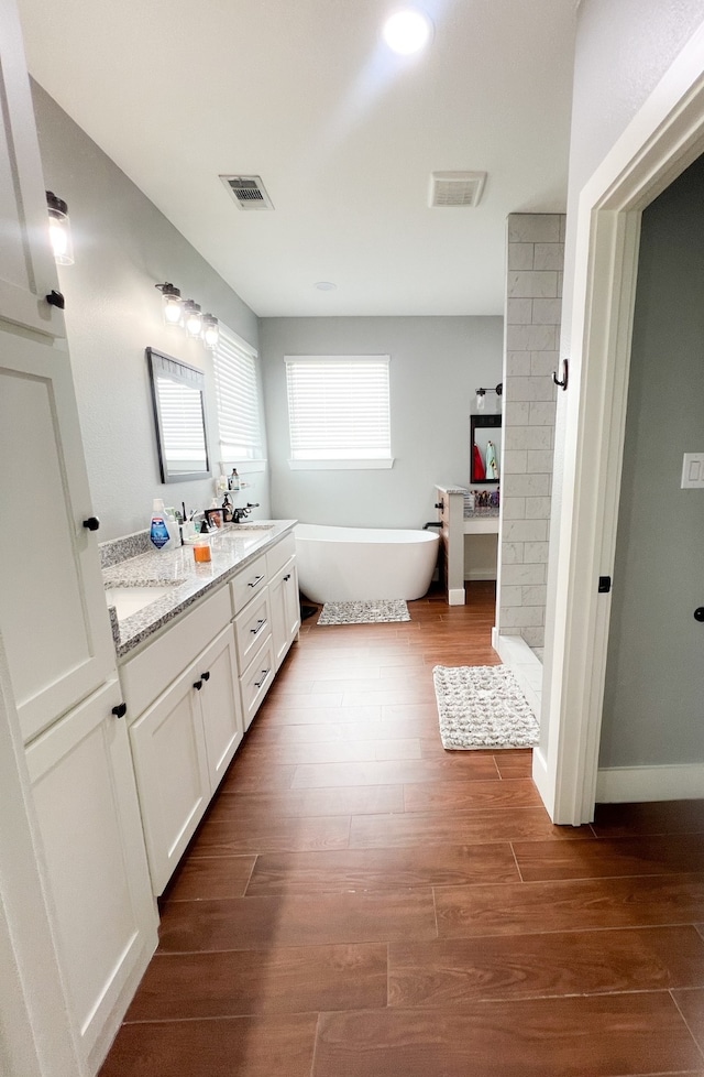 bathroom featuring vanity, hardwood / wood-style floors, and plus walk in shower