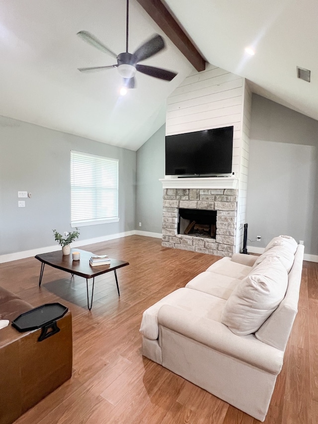 living room featuring ceiling fan, vaulted ceiling with beams, hardwood / wood-style floors, and a fireplace