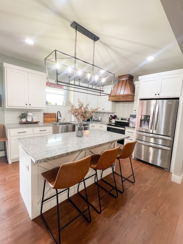 kitchen featuring a chandelier, stainless steel appliances, dark hardwood / wood-style flooring, premium range hood, and sink