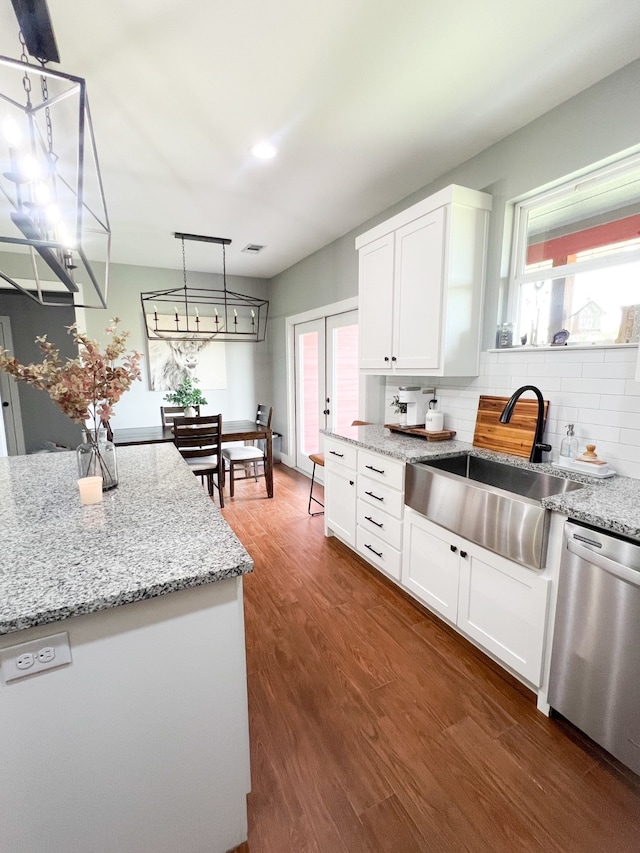 kitchen featuring dark hardwood / wood-style flooring, sink, white cabinetry, and stainless steel dishwasher