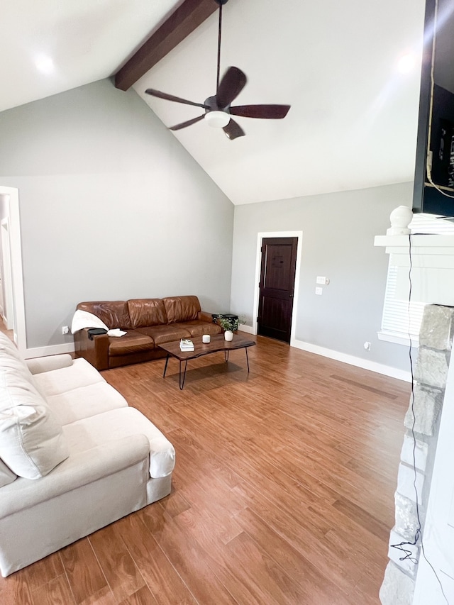 living room with ceiling fan, hardwood / wood-style flooring, and vaulted ceiling with beams