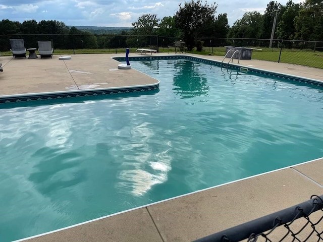 view of pool featuring a diving board and a patio area