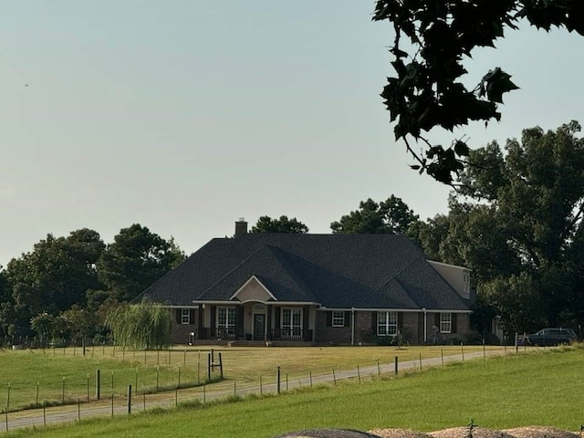 view of front of home featuring a front lawn and a rural view