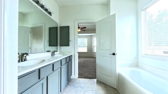 full bath featuring double vanity, a garden tub, a sink, and tile patterned floors