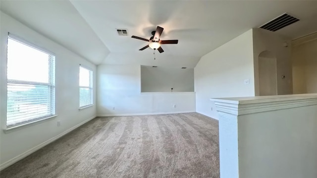 unfurnished room featuring lofted ceiling, visible vents, ceiling fan, and light carpet