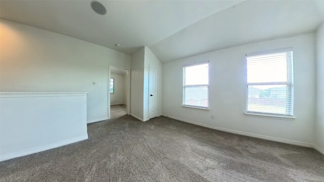 interior space featuring lofted ceiling, carpet flooring, and baseboards