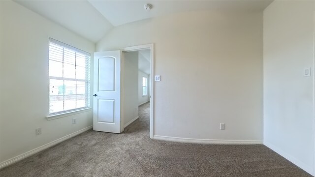 unfurnished bedroom with carpet, baseboards, and vaulted ceiling