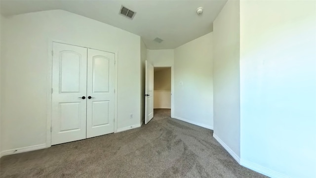 unfurnished bedroom with lofted ceiling, light colored carpet, and a closet