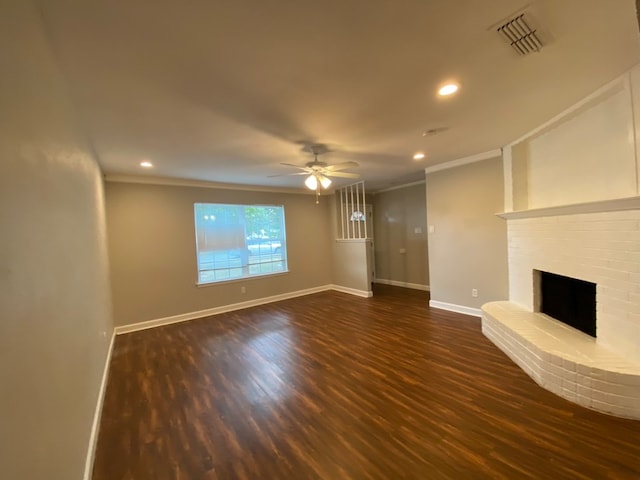 unfurnished living room with crown molding, ceiling fan, dark hardwood / wood-style floors, and a fireplace