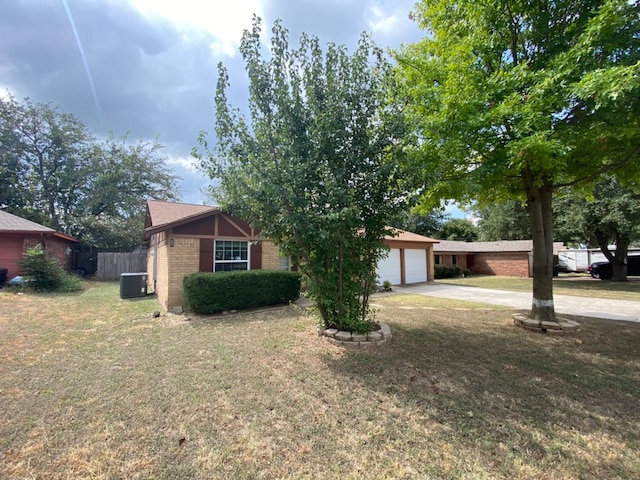 view of front of property with a garage, a front lawn, and central air condition unit