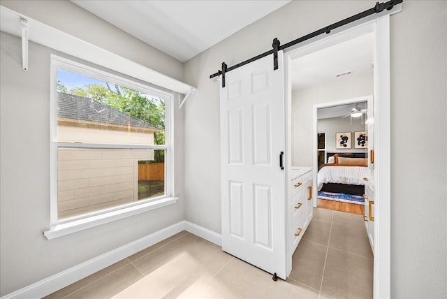 interior space with a barn door and light tile patterned floors