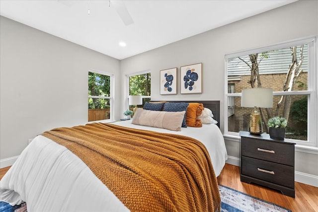 bedroom with ceiling fan and light hardwood / wood-style floors