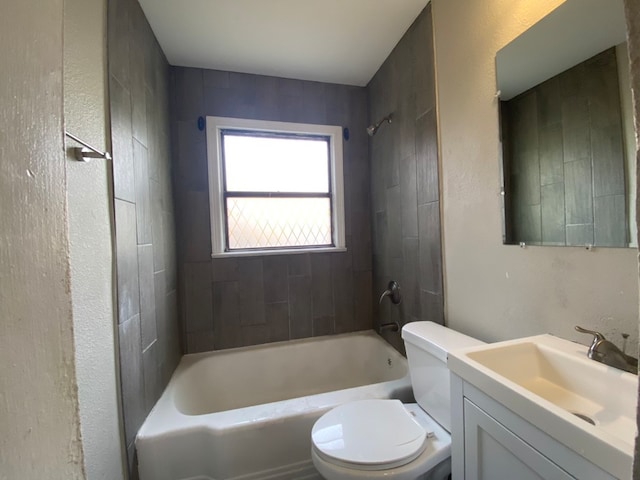 full bathroom with tiled shower / bath, vanity, and toilet