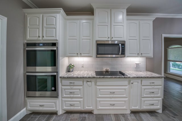 kitchen with dark wood-type flooring, stainless steel appliances, backsplash, and white cabinets