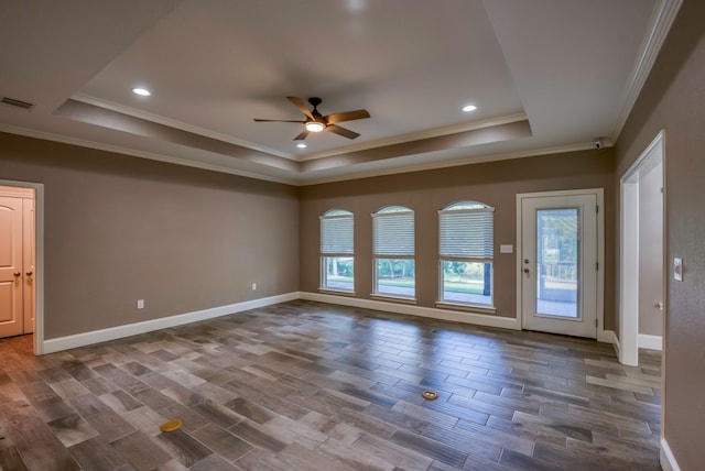 spare room featuring a tray ceiling, ceiling fan, hardwood / wood-style flooring, and ornamental molding