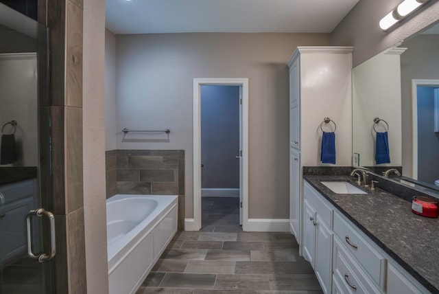 bathroom with vanity, a bath, and hardwood / wood-style flooring