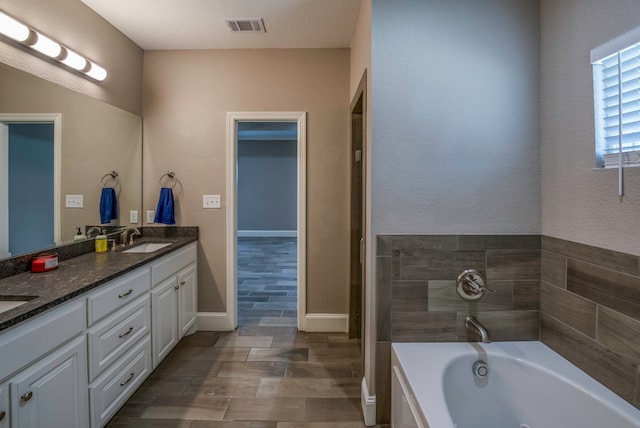 bathroom with a tub, hardwood / wood-style flooring, and vanity