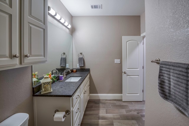 bathroom featuring toilet, hardwood / wood-style flooring, and vanity