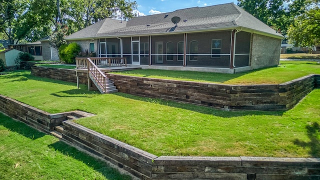 rear view of house with a sunroom and a lawn