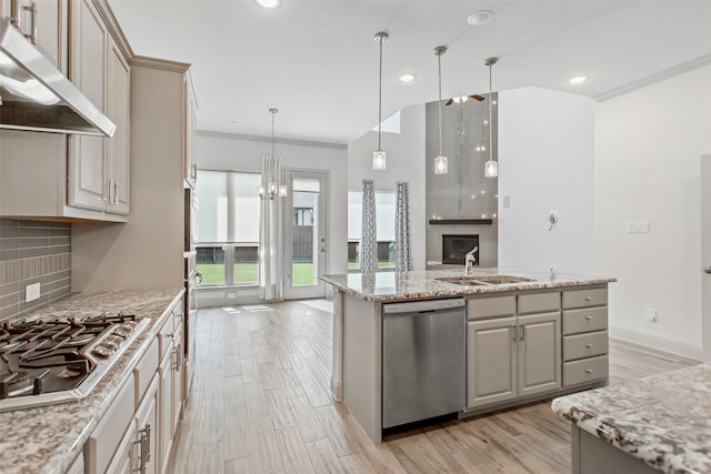 kitchen with decorative light fixtures, light stone counters, stainless steel appliances, light hardwood / wood-style floors, and decorative backsplash