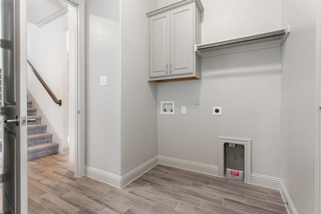 laundry room with cabinets, hardwood / wood-style floors, electric dryer hookup, hookup for a gas dryer, and washer hookup