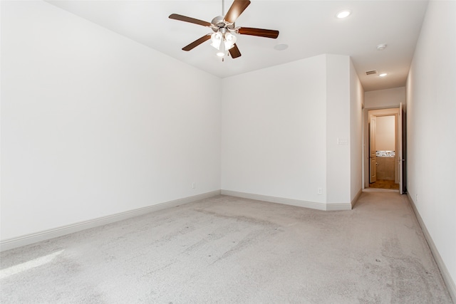 spare room featuring ceiling fan and light carpet