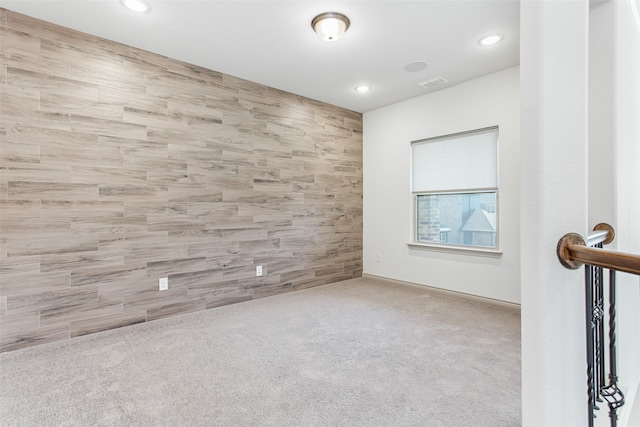 empty room featuring tile walls and light colored carpet