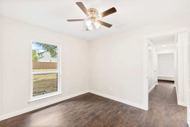 empty room featuring ceiling fan, dark hardwood / wood-style flooring, and a healthy amount of sunlight