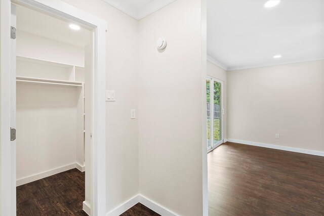 hall with dark wood-type flooring and ornamental molding