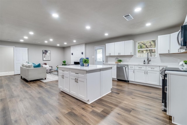 kitchen featuring a center island, stainless steel appliances, and white cabinets