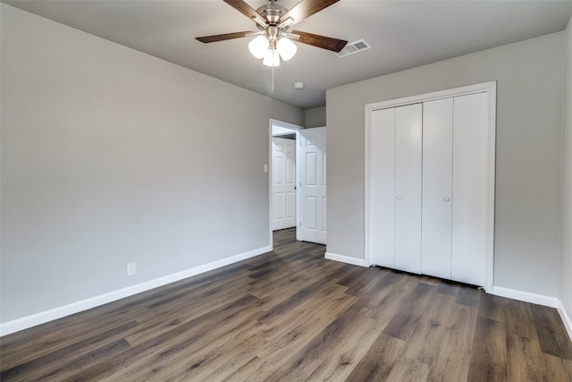 unfurnished bedroom with dark wood-type flooring, ceiling fan, and a closet