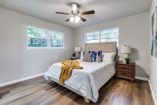 bedroom with dark hardwood / wood-style flooring and ceiling fan