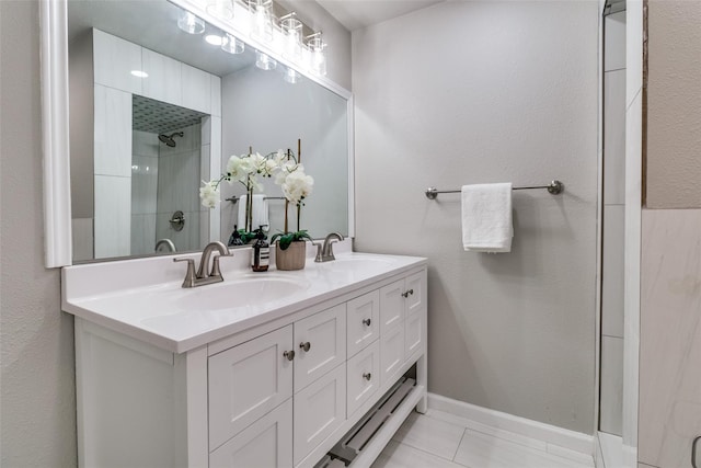 bathroom with vanity, tiled shower, and tile patterned flooring