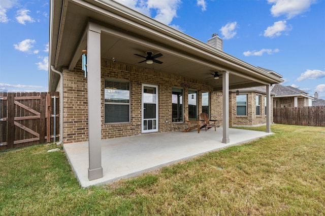 rear view of property with a lawn, ceiling fan, and a patio area