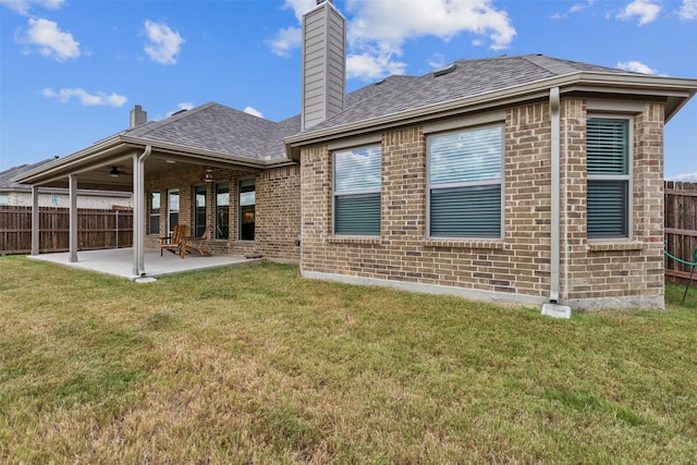 rear view of property with a lawn, ceiling fan, and a patio area