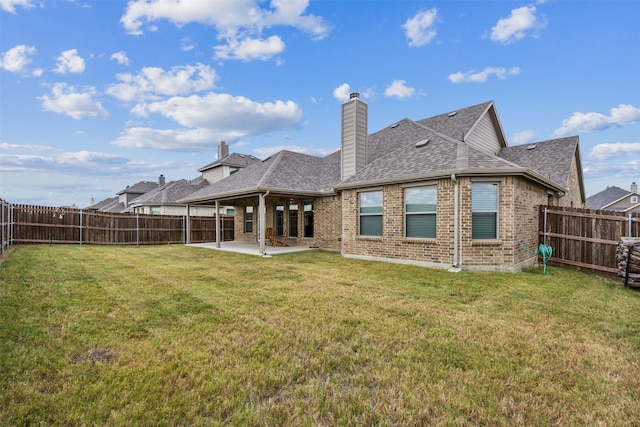 back of house with a yard and a patio area