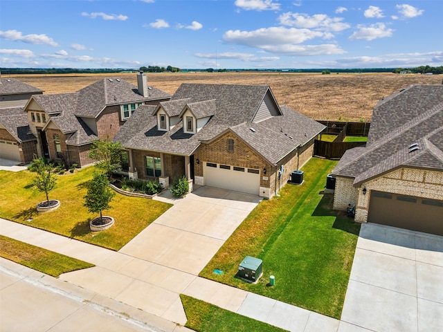 view of front facade with a garage, central AC, and a front yard