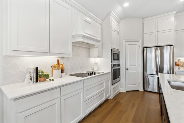 kitchen featuring white cabinetry, appliances with stainless steel finishes, light stone countertops, and dark wood-type flooring