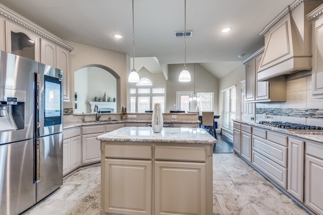 kitchen with a kitchen island, stainless steel appliances, custom range hood, and a healthy amount of sunlight