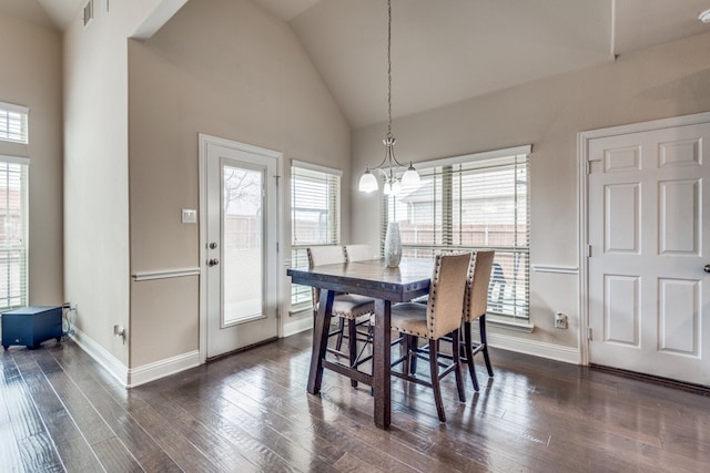 dining space with high vaulted ceiling, an inviting chandelier, and dark hardwood / wood-style floors