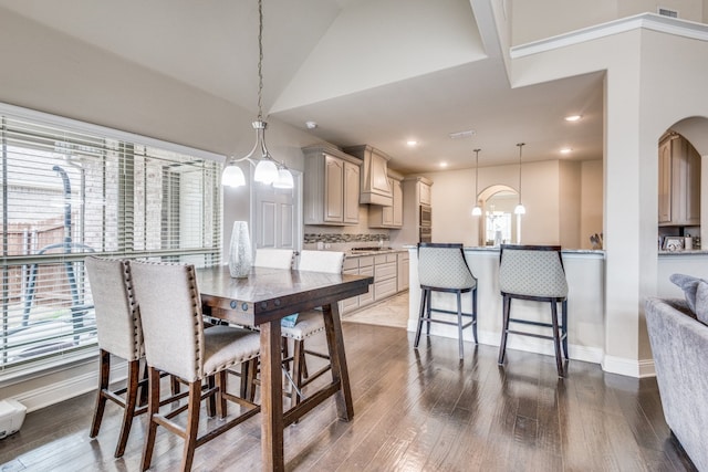 dining room featuring lofted ceiling, wood-type flooring, and a chandelier