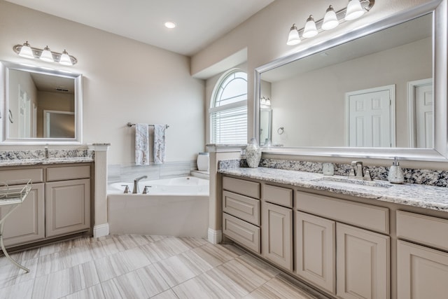 bathroom featuring a tub to relax in, vanity, and tile patterned floors