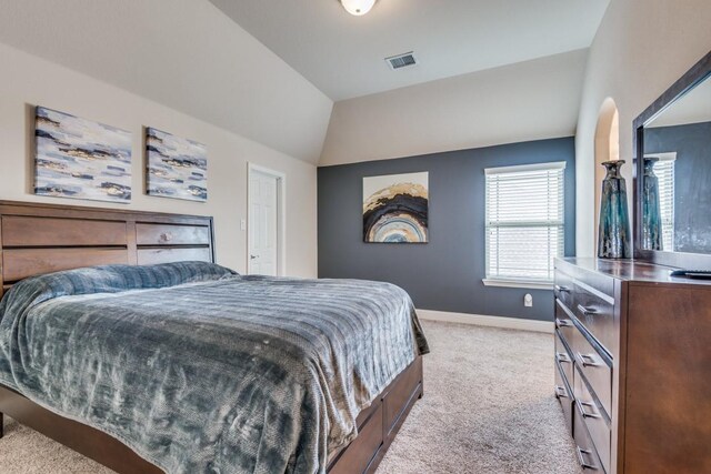 carpeted bedroom with lofted ceiling