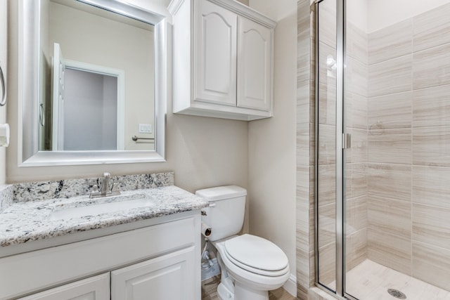 bathroom with an enclosed shower, toilet, and vanity