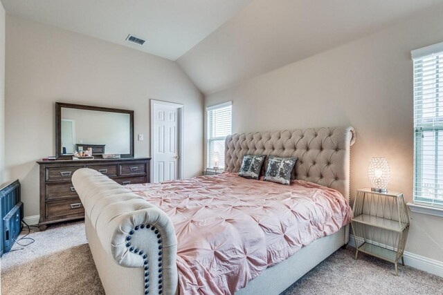 bedroom featuring multiple windows, light colored carpet, and vaulted ceiling