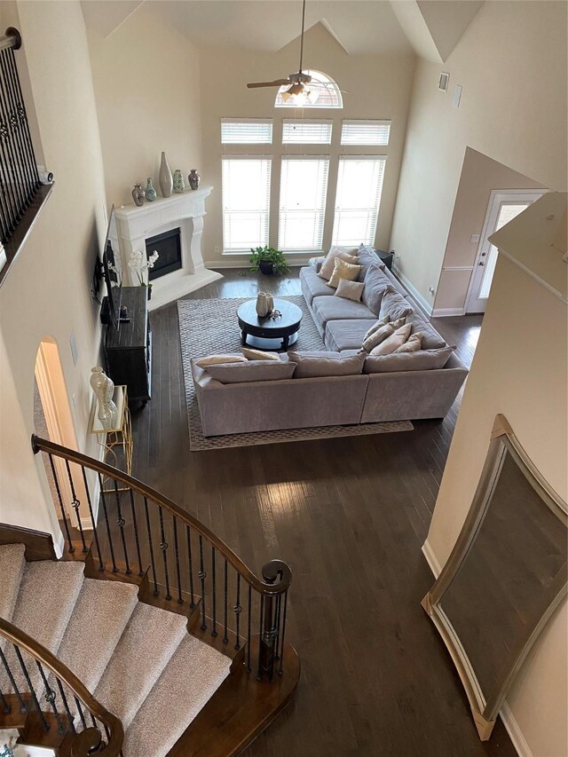 living room with high vaulted ceiling, hardwood / wood-style floors, and ceiling fan