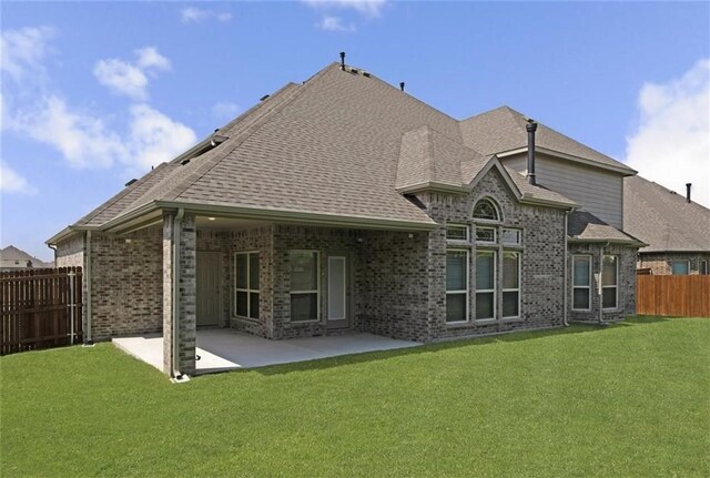 rear view of house featuring a patio area and a yard