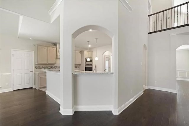 unfurnished living room featuring a high ceiling and dark hardwood / wood-style floors