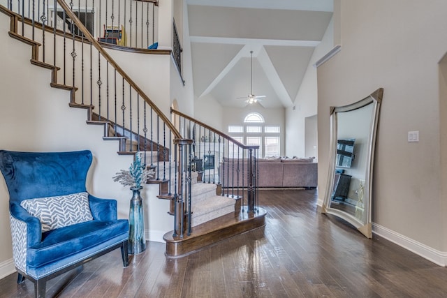 foyer with dark wood-type flooring, ceiling fan, and high vaulted ceiling