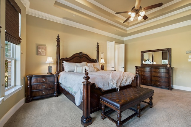 bedroom featuring crown molding, a raised ceiling, light colored carpet, and ceiling fan